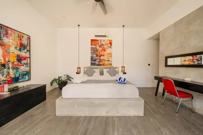 a bedroom with a large bed and a desk at Elegant Modern 4BR Retreat in the Heart of Berawa in Canggu