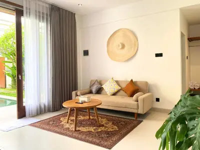 a living room with a couch and a table at De Awan Villa in Kerobokan