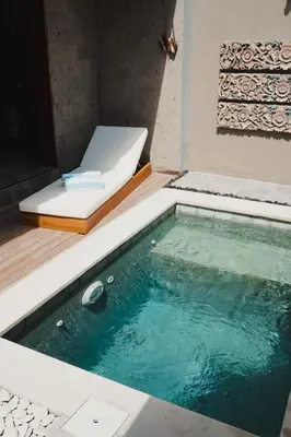 a small pool of water next to a bed at Dikubu Belong in Seminyak