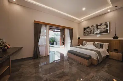 a bedroom with a bed and a sliding glass door at Dikubu Belong in Seminyak