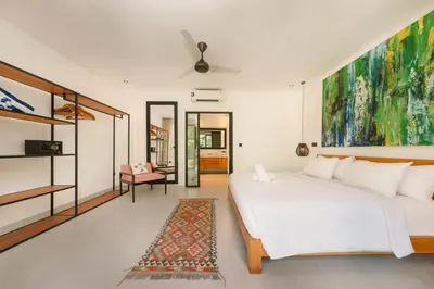 a bedroom with a large white bed and a rug at Spacious 5BR Modern Simplicity, Near Canggu's Best in Canggu