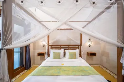 a bedroom with a bed with a canopy at Villa Gema Asri - Boho Chic Oasis in Central Petitenget in Seminyak