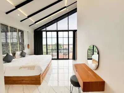 a bedroom with a large bed and a mirror at Villa Arti in Seminyak