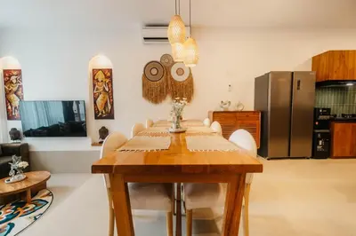 a dining room with a wooden table and a refrigerator at Villa Bens Luxury - 3BR Villa in Kerobokan in Kerobokan