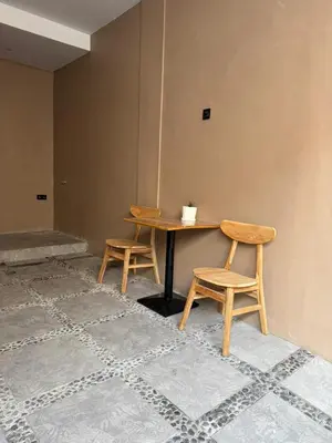 a table and two chairs in a room at Flamboyant Guesthouse in Seminyak
