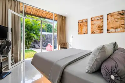 a bedroom with a bed and a large window at Davion 6 BR Private Pool Villa in Seminyak