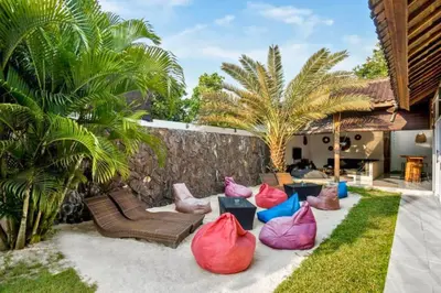 a patio with colorful bags on the grass at Davion 6 BR Private Pool Villa in Seminyak