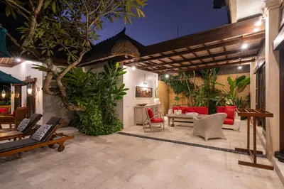 an outdoor patio with a couch and chairs and trees at 4-Bedroom Villa - Large swimming pool - Ideal place for friends and families in Seminyak