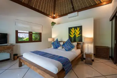 a bedroom with a large bed with blue pillows at 4-Bedroom Villa - Large swimming pool - Ideal place for friends and families in Seminyak