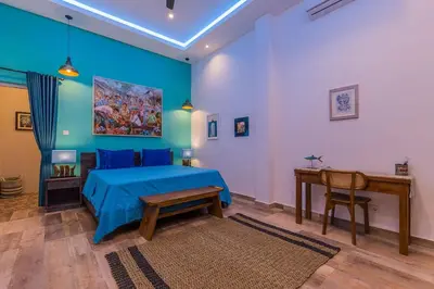 a bedroom with a blue bed and a desk at Villa Kanari,5 bed & pool in Seminyak