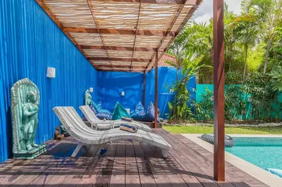 a patio with two lounge chairs and a pool at Villa Kanari,5 bed & pool in Seminyak
