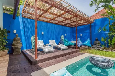 an outdoor patio with a pool and a pergola at Villa Kanari,5 bed & pool in Seminyak