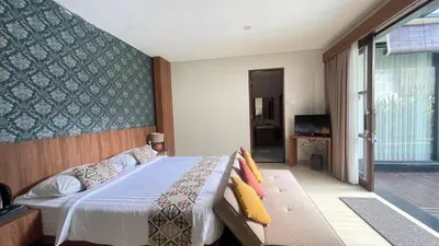 a bedroom with a bed and a couch at Villa Lans By Baliem Villa in Jimbaran