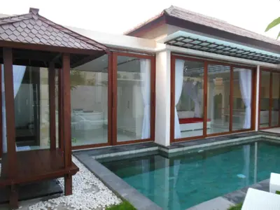 a villa with a swimming pool and a house at HK Villa Bali in Legian