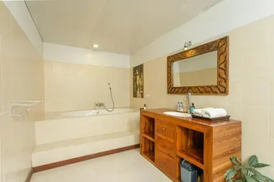 a bathroom with a tub and a sink and a mirror at Abimanyu Villa 2 Seminyak in Seminyak