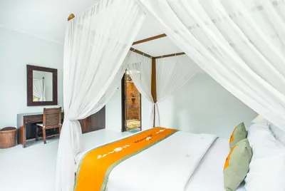 a bedroom with a canopy bed with a window at Abimanyu Villa 2 Seminyak in Seminyak