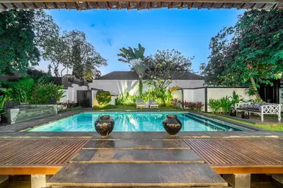 a swimming pool with a wooden table and a bench at Ocean Two 3BR Private Pool in Oberoi Seminyak in Seminyak