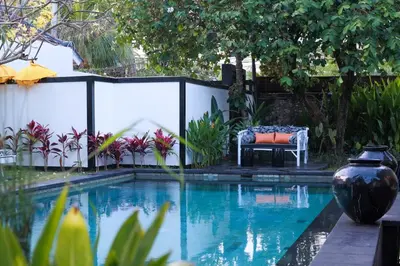 a pool with a bench next to a fence at Ocean Two 4BR Family Retreat Oberoi in Seminyak