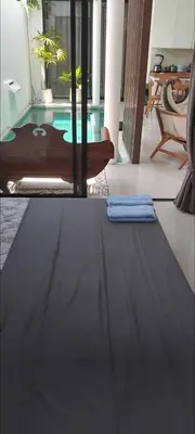 a living room with a table and a swimming pool at Serene Bali Villa with Private Pool and Antiqued Charm in Balian