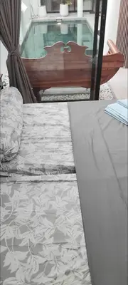 a bedroom with a bed and a bench and a table at Serene Bali Villa with Private Pool and Antiqued Charm in Balian