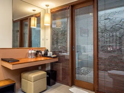a bathroom with a vanity and a sink and a toilet at Savvoya Hotel Seminyak in Seminyak