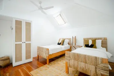 a white bedroom with two beds and a doorway at Luxurious & Bespoke Upscale 3BR Villa in Canggu in Canggu