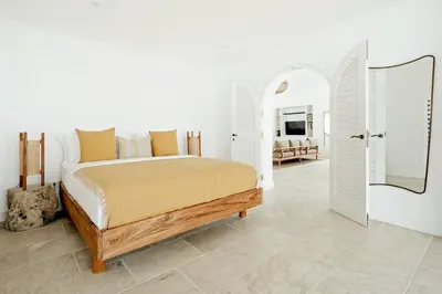 a white bedroom with a bed and a mirror at Luxurious & Bespoke Upscale 3BR Villa in Canggu in Canggu