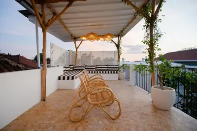 a wooden bench sitting on a balcony with a view at Luxurious & Bespoke Upscale 3BR Villa in Canggu in Canggu