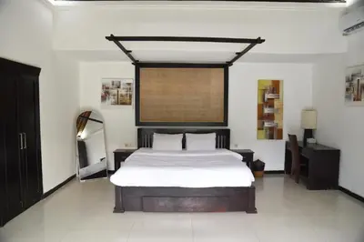 a bedroom with a large bed and a window at Casa Veluna - Seminyak in Seminyak