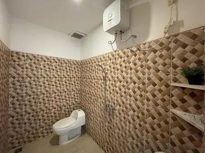 a bathroom with a toilet and a shower in it at Mopoe Guesthouse in Sanur