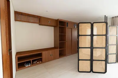 a room with a bed with wooden cabinets and shelves at JB Hazel, 4Bedroom villa in Jimbaran in Jimbaran
