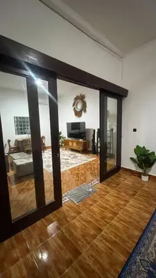 a living room with glass doors and a wooden floor at 2 Bedrooms Private Pool Villa Indi K Kerobokan in Seminyak