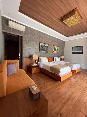 a large bedroom with two beds and a couch at Villa Jiwanta by Maheswara in Kerobokan
