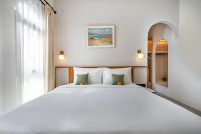 a bedroom with a large white bed with green pillows at Jivani Villa - 9 min to Nusa Dua Beach - Brand New, Cinema Room, BBQ, 3Bdr in Jimbaran