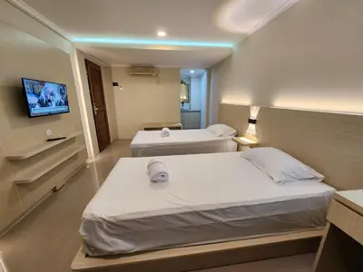 a hotel room with two beds and a tv at Bali Balitung in Seminyak