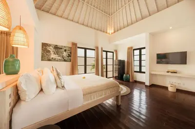 a bedroom with a large bed and a television at Stylish 3BR Escape, 5 Mins to Seminyak Beach in Seminyak