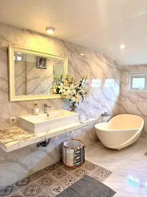 a bathroom with a sink and a large mirror at Wangi Melati Homestay in Kerobokan