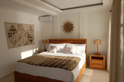 a bedroom with a large bed with two pillows at Wangi Melati Homestay in Kerobokan
