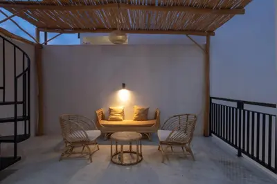 a patio with a table and chairs and a lamp at La Casa Gomes in Nusa Dua