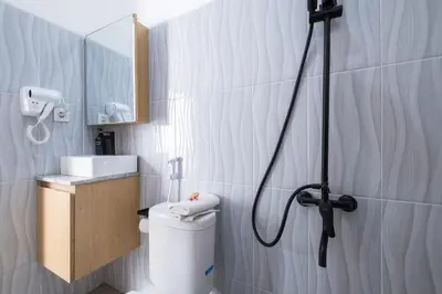 a bathroom with a shower with a toilet and a sink at La Casa Gomes in Nusa Dua