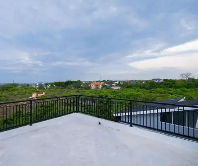 a balcony with a black railing and a view at La Casa Gomes in Nusa Dua