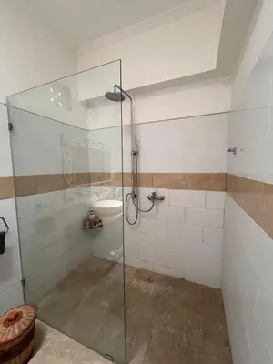 a glass shower in a bathroom with a toilet at Villa Harmony Moon in Denpasar