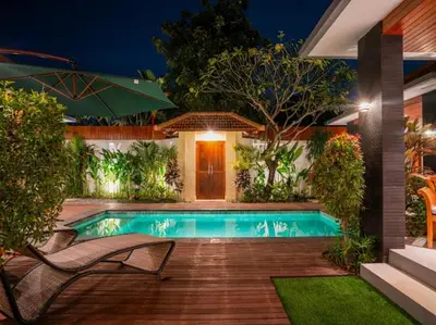 a swimming pool in front of a house at night at Harbie Villa 2 in Badung