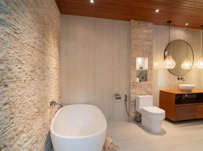 a bathroom with a white tub and a toilet at Harbie Villa 2 in Badung