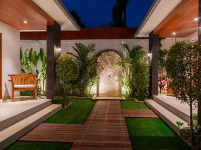 a garden with a wooden walkway with a bench at Harbie Villa 2 in Badung