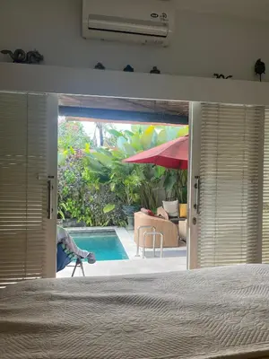 a bedroom with a view of a swimming pool through the door at Villa Harmony Moon in Seminyak