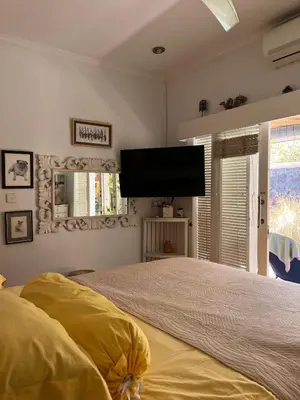 a bedroom with a bed and a flat screen tv at Villa Harmony Moon in Seminyak