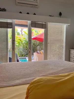 a bedroom with a large bed and sliding glass doors at Villa Harmony Moon in Seminyak