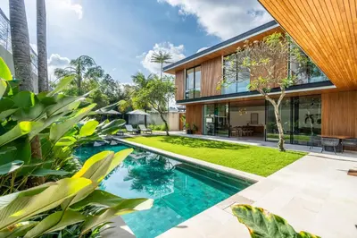 an external view of a house with a swimming pool and plants at Villa Semilir Sendja, Canggu in Canggu