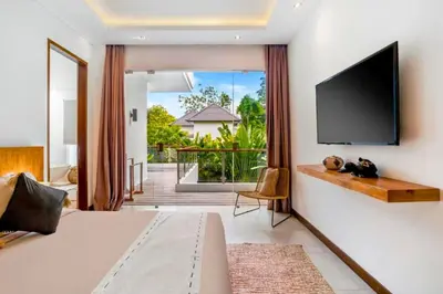 a bedroom with a flat screen tv on a wall at Feodora Peaceful 4 BR Private Pool Villa in Seminyak